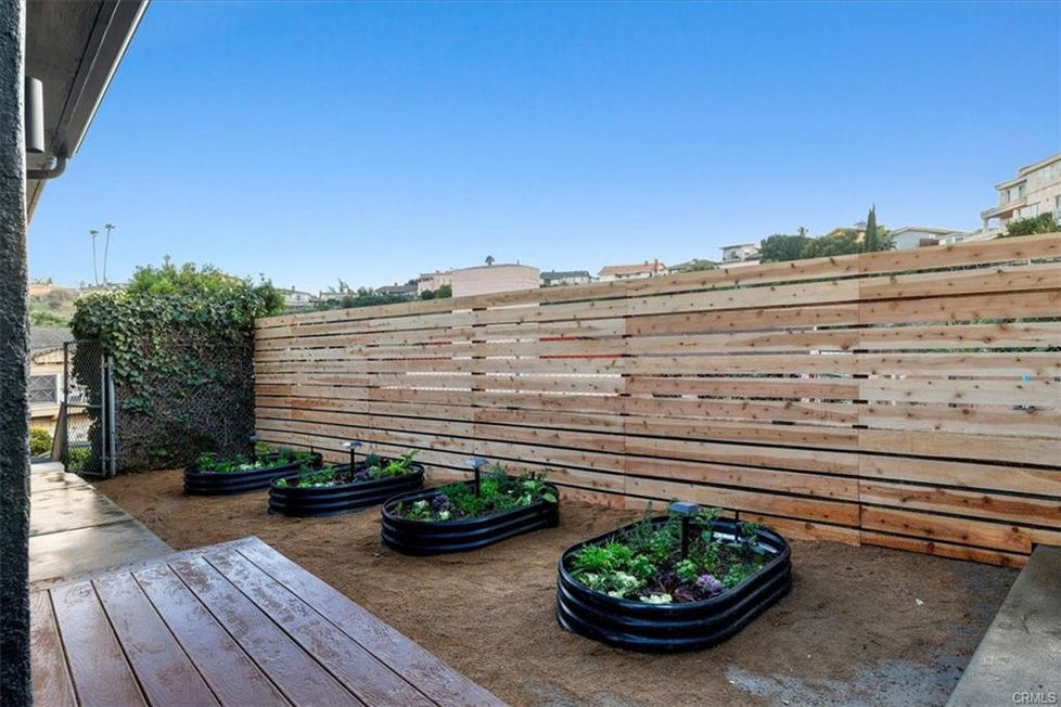 a modern wooden fence with a row of planters boxes 