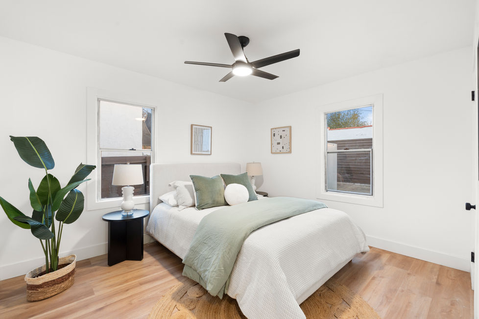 a bedroom with a queen size bed and a ceiling fan