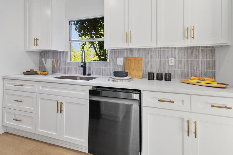 a kitchen with white cabinets and a stainless steel dishwasher