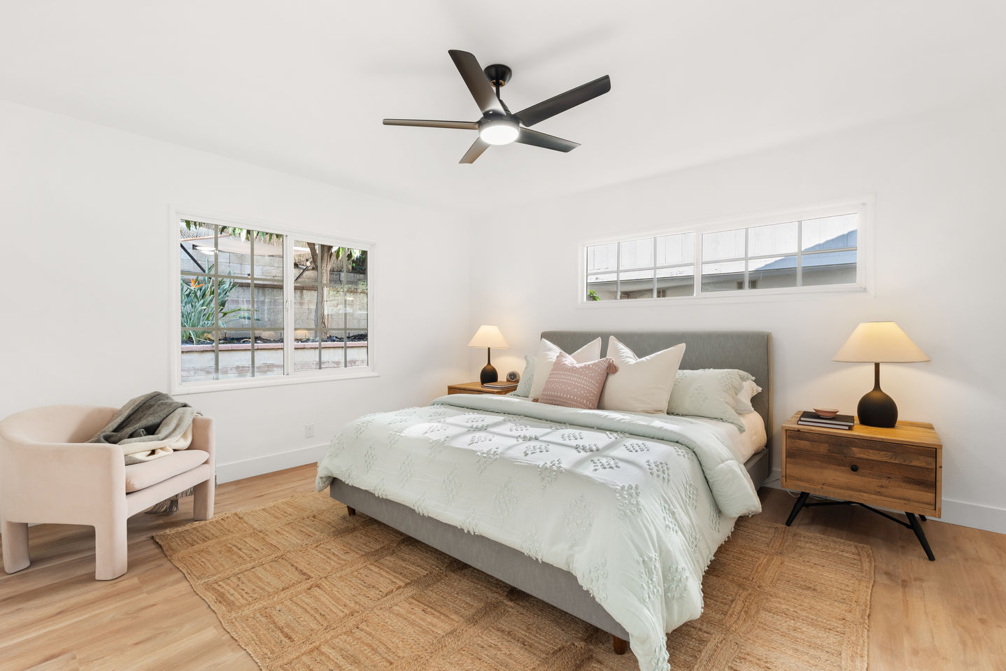 a bedroom with a CalKing bed and a ceiling fan