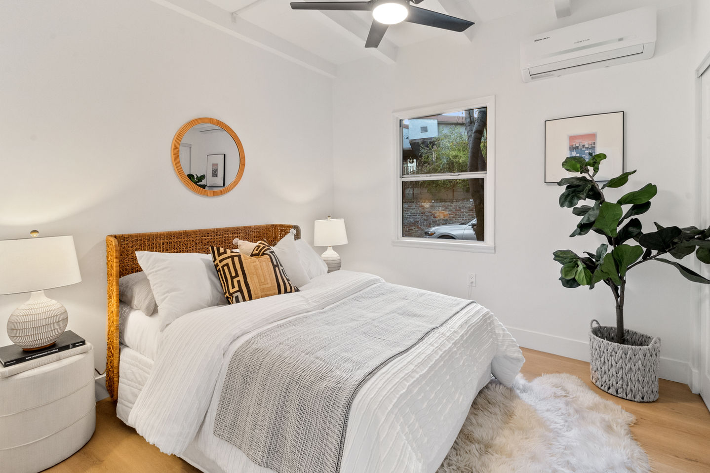 a bedroom with a queen size bed a mirror and a ceiling fan