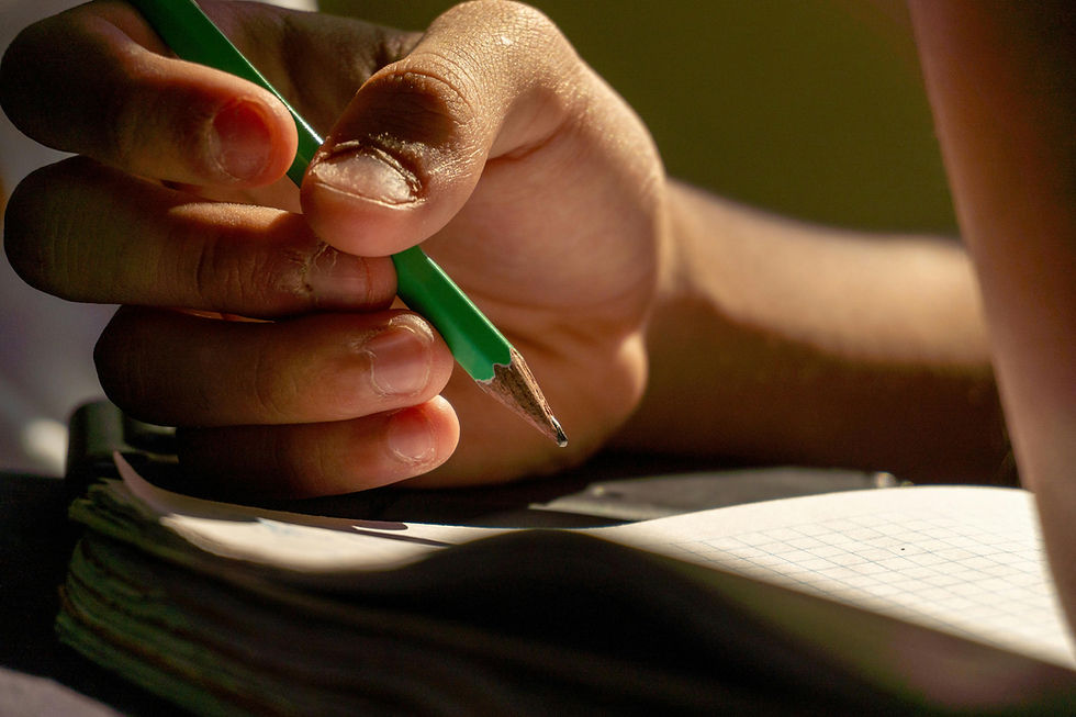 A person holding a pencil above paper