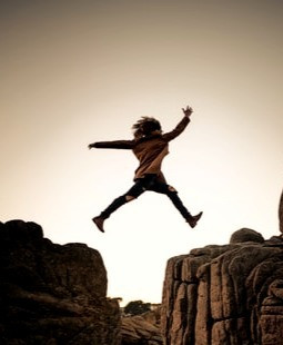 Image of a woman leaping across rocks