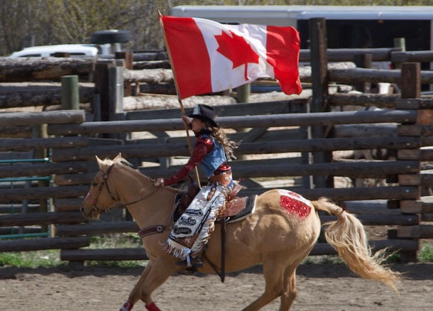 Rider on horseback at the rodeo grounds wearing blue western clothing
