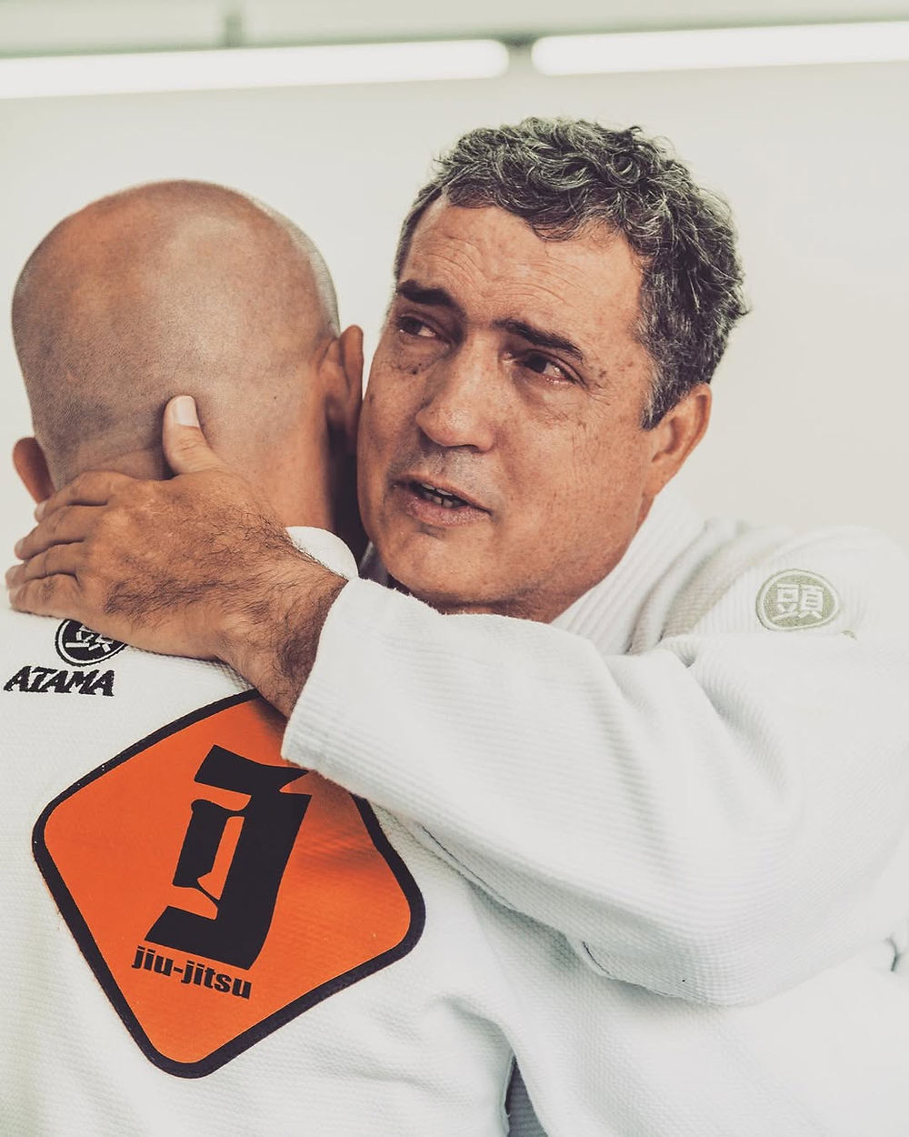 Mestre de jiu-jitsu abraçando aluno, história flexa jiu jitsu