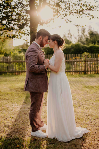 Brautpaar hält Hände, sieht sich an, HOCHZEITEN, Garten, Hochzeitsfotograf Thüringen, Sonnenlicht.