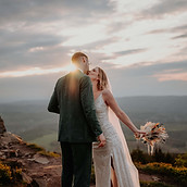 Ein Hochzeitspaar küsst sich im Sonnenuntergang