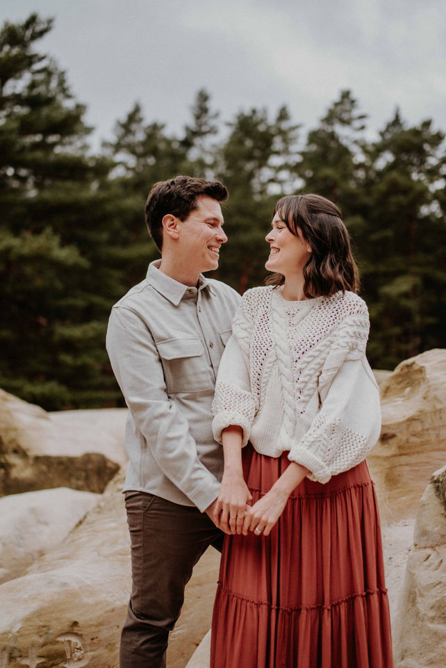 Ein verlobtes Paar hält Hände, und sieht sich verliebt an - Hochzeitsfotografin Thüringen