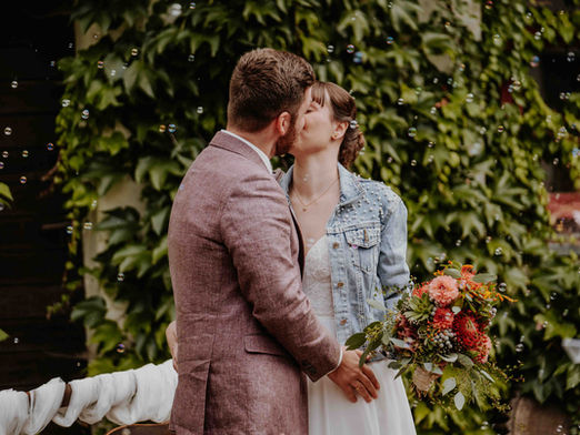 Ein Brautpaar küsst sich zwischen Seifenblasen