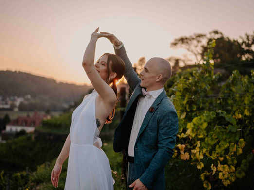 Ein Brautpaar tanzt im Abendlicht zwischen Weinreben