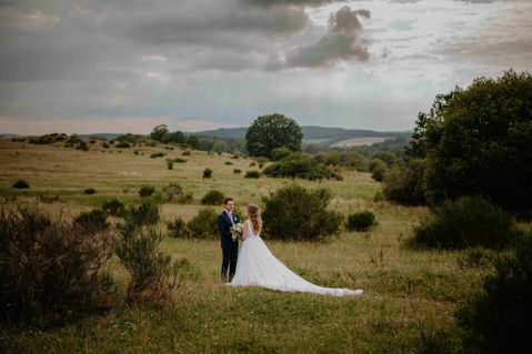 Eine Braut und ein Bräutigam stehen in der Heidelandschaft bei Plauen für ein After Wedding Shooting