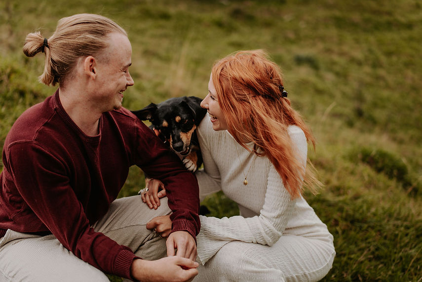 Glückliches Paar mit Hund auf Grasfeld, emotionale Fotografie Thüringen.