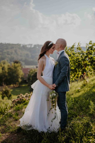 Eine Braut wird von ihrem Mann auf die Stirn geküsst