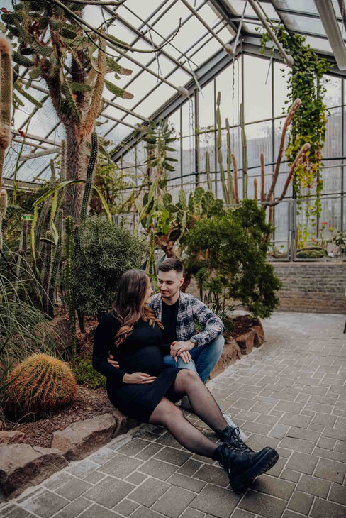 Emotionale Babybauchbilder zwischen kahlen Bäumen und warmem Licht im Botanischen Garten