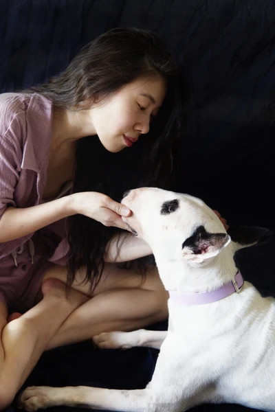 Girl cupping dog's chin