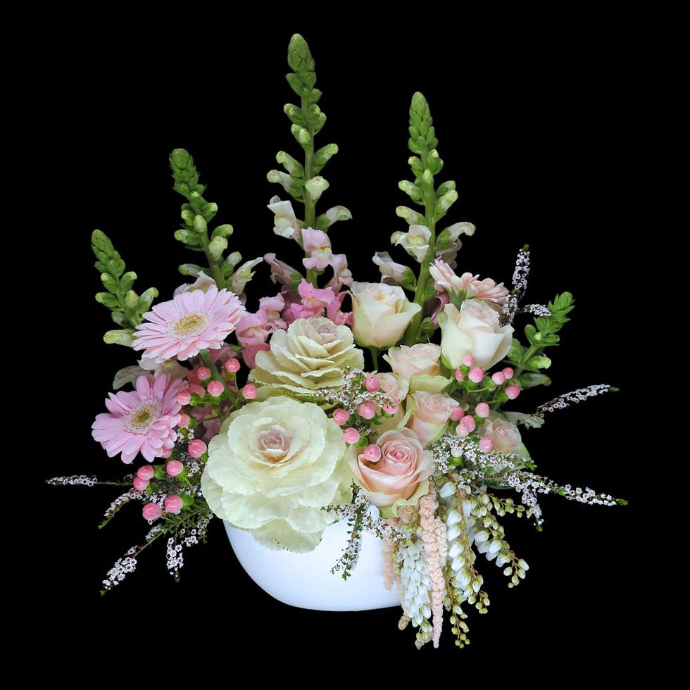 Selection of pink flowers arranged in a white ceramic boat shaped vase