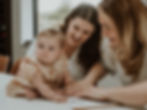 Smiling family sitting together, with children looking at a framed foil keepsake print