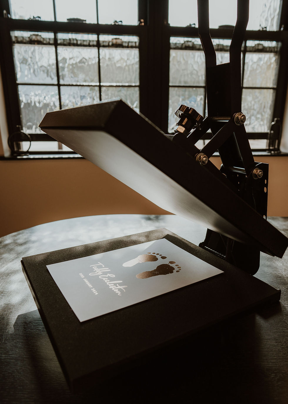 Foil printing press in action creating baby footprint keepsake