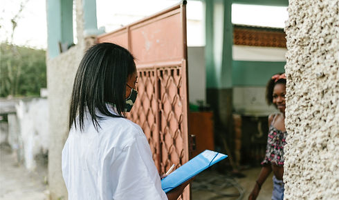 A woman wearing a face mask is standing in front of a door.
