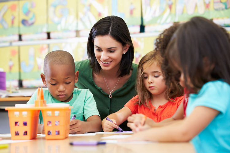 Adult with multiple young children coloring with crayons