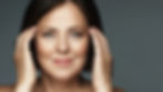 Middle-aged woman with good skin touching her temples