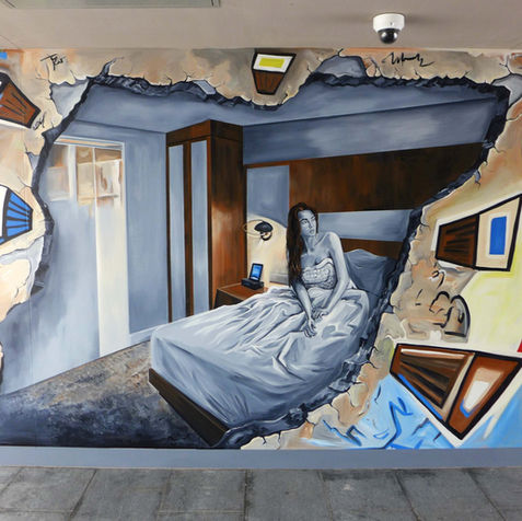 Surreal mural showing a hand reaching through an illusion of a broken wall