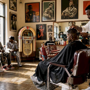 Barber cutting client’s hair in local shop