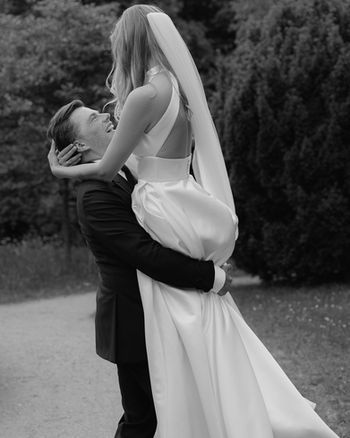 Der Bräutigam nimmt die Braut in die Arme und wirbelt sie herum