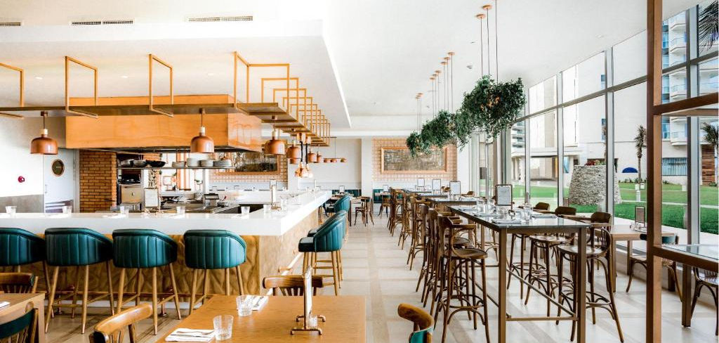 Restaurante moderno com bar e mesas no Iberostar Paraíso Maya