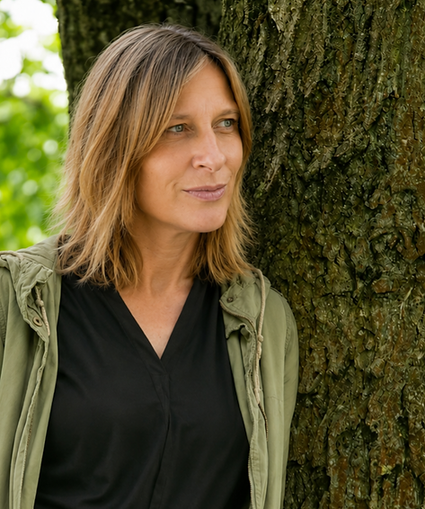 Frau steht an Baum gelehnt