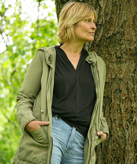 Frau angelehnt an Baum