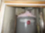 Attic insulation covering water heater flue pipe creating safety hazard in Austin home