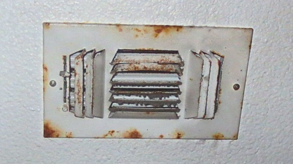 Rust forming on an AC ceiling supply register caused by long-term high indoor humidity in an Austin home