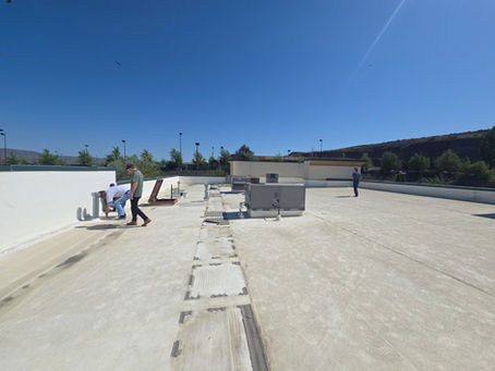Roofing crew inspecting a commercial flat roof