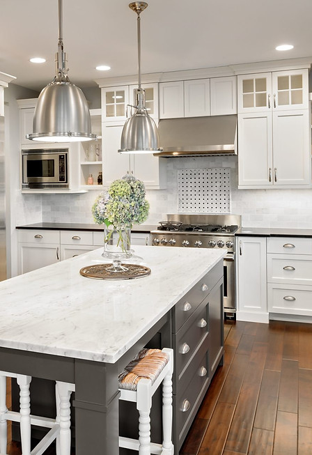 Modern kitchen with stainless steel appliances and white cabinetry, a large island