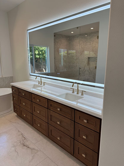 Bathroom vanity with double sinks and large mirror; Remodeling Experts OC.