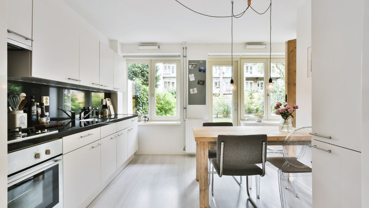 Bright modern kitchen with white cabinets and dining area