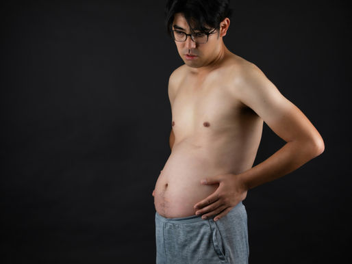 A man with his bloated SIBO belly after eating a healthy meal.