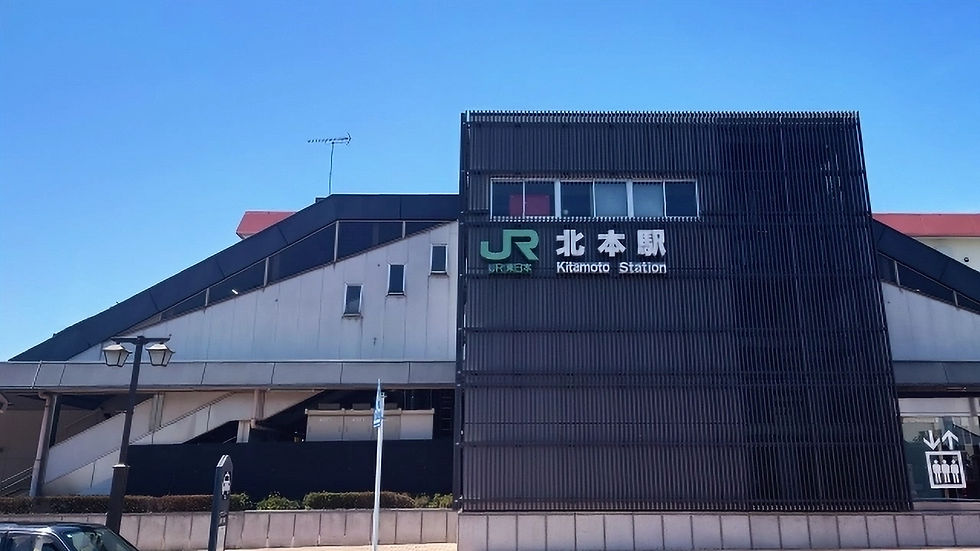 青空の下、JR北本駅の黒い外観が見える。駅名表示のあるモダンな駅舎の外観。