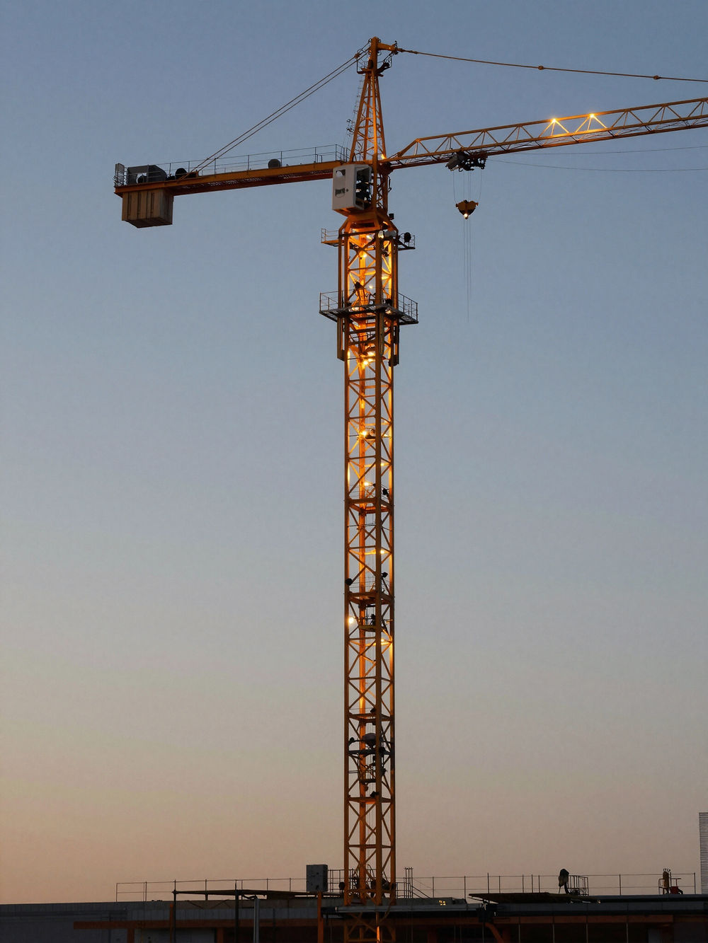 Baukran auf Baustelle bei Sonnenuntergang