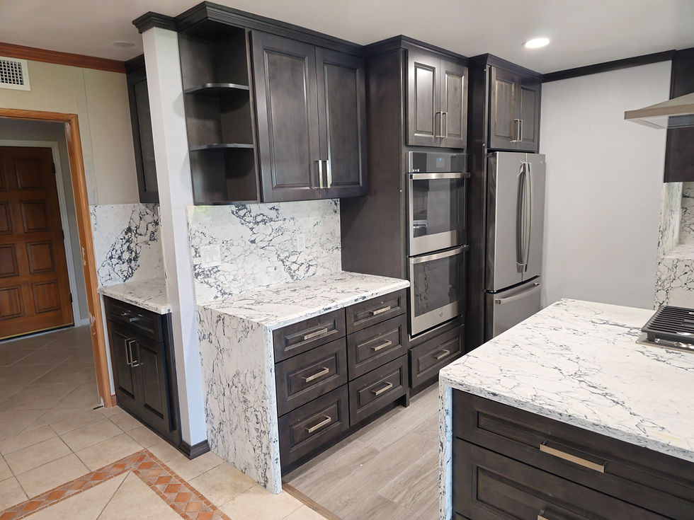 Dark wood kitchen cabinets with marble countertops and stainless steel appliances.