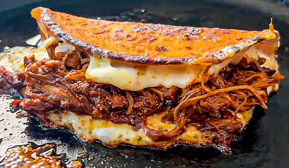 Um Taco Birria muito recheado com carne e queijo.