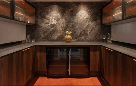 Modern wet bar with marble backsplash and wooden cabinetry with Wind Royal SL