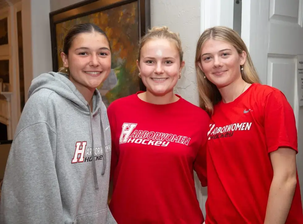 Enthusiastic children playing sports on a sunny field wearing vibrant team t-shirts with visible numbers and logos, showcasing youth athletic apparel