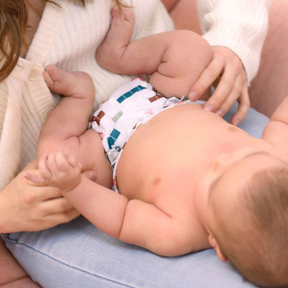 Mutter mit ihrem Baby in Stoffwindel auf dem Wickeltisch