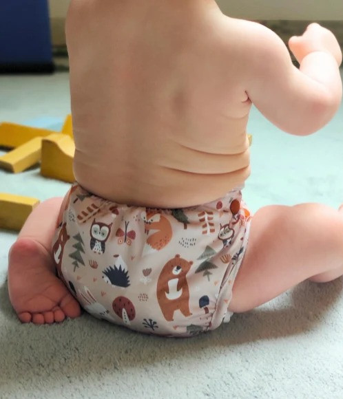 Baby mit Lumina Pocketwindel bekleidet spielt mit Bauklötzen