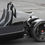 Thumbnail: Black three-wheeled vehicle with rear wheel and suspension on asphalt background.