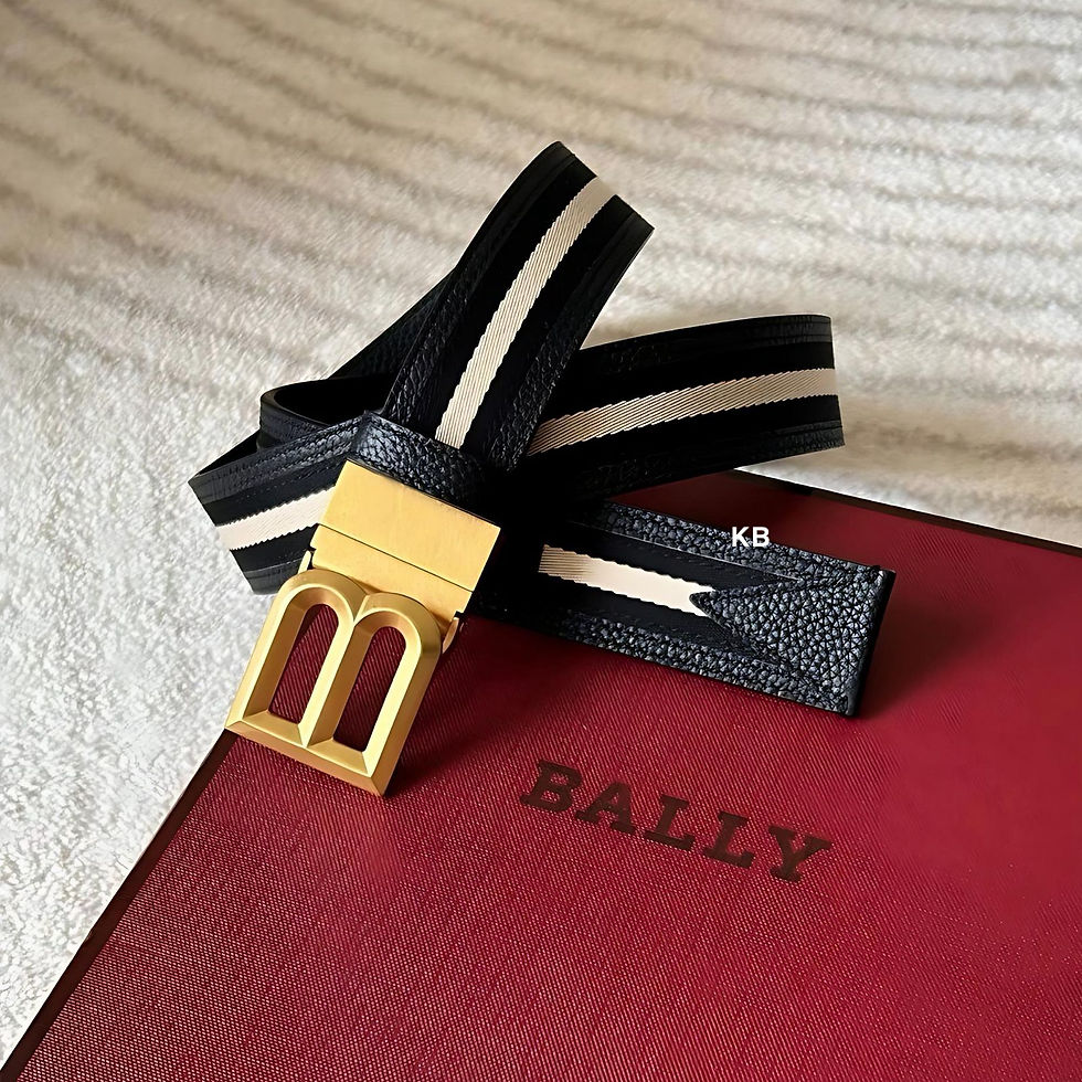Bally reversible belt with a gold buckle on a red surface