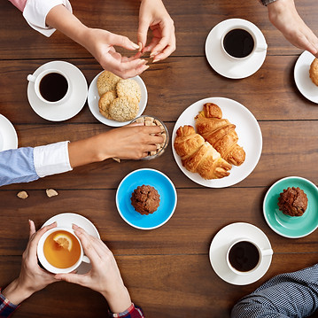 manos-de-la-gente-en-la-mesa-de-madera-con-cruasanes-y-cafe.jpg