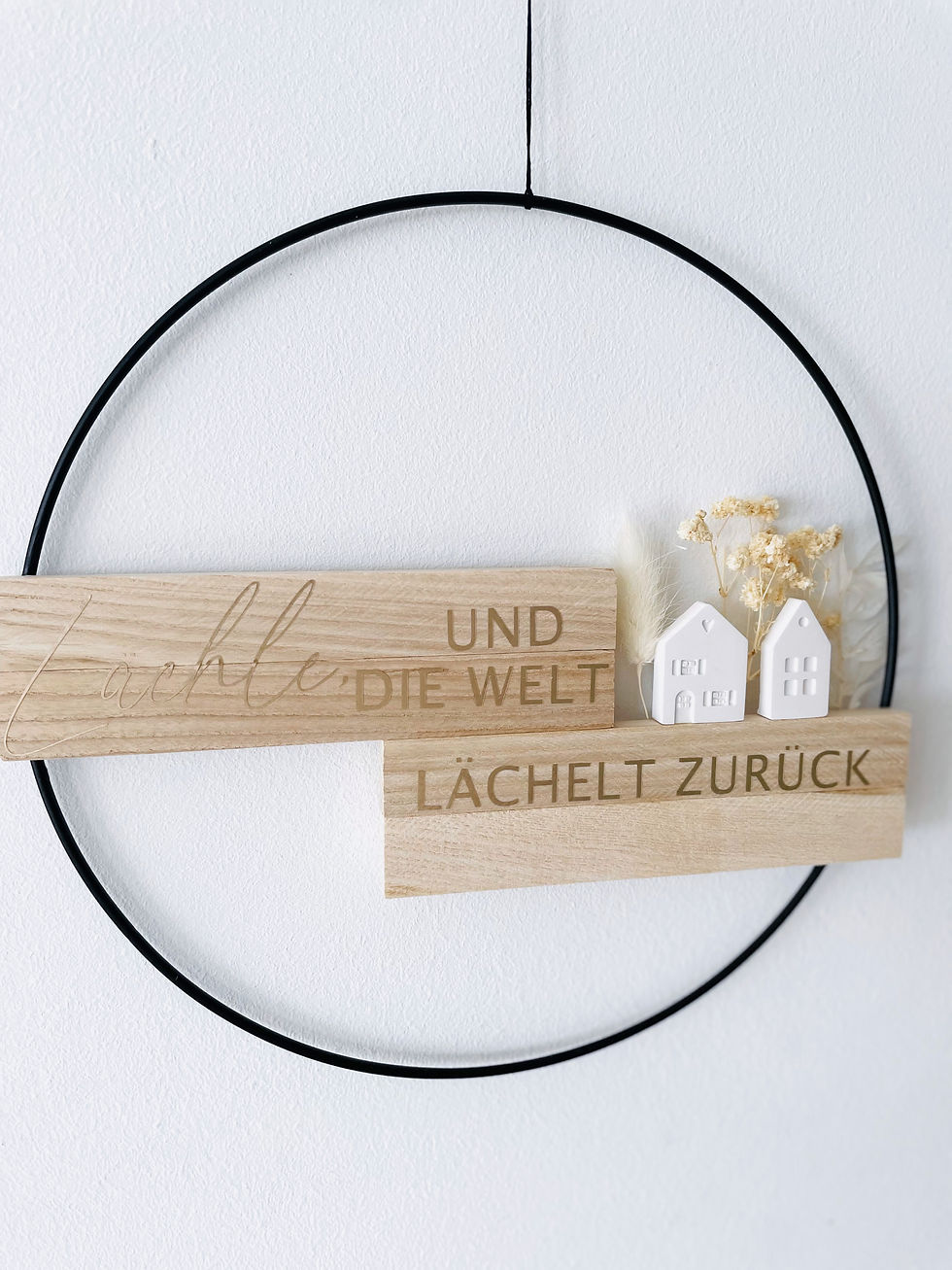 Miniaturbild: Holzregal mit Spruch "Und die Welt lachelt zurück" an schwarzem Ring
